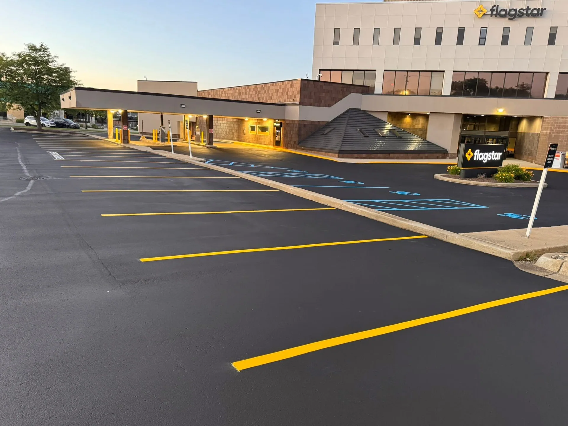 Sealcoated commercial parking lot at dusk with blue ADA stalls